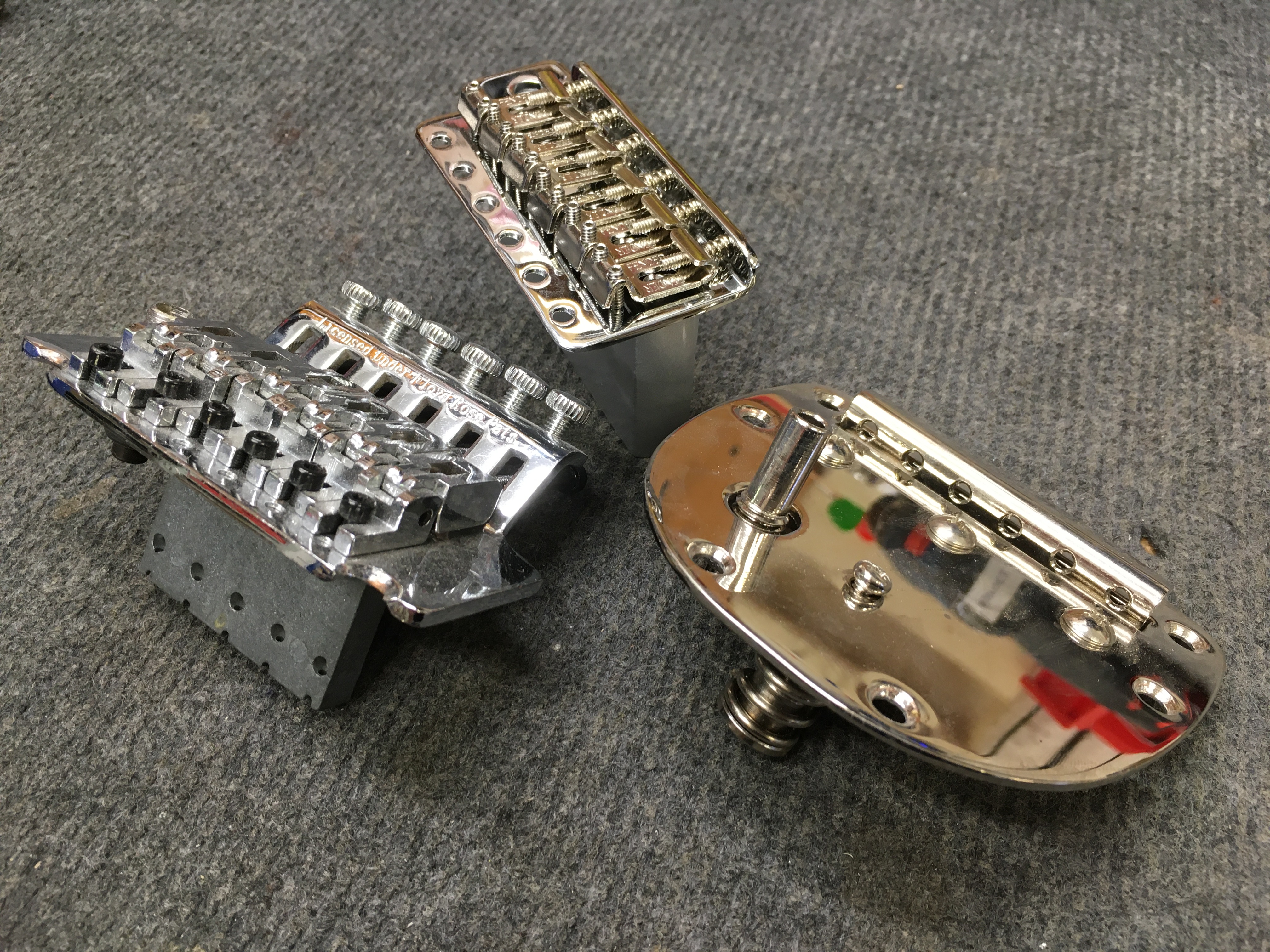 Zleva tremolo typu Floyd Rose, uprostřed Fender stratocaster tremolo a vpravo tremolo systém pro modely Jaguar a Jazzmaster