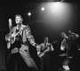 Elvis žije aneb pravděpodobně nejslavnější a nejznámější konspirační teorie hudebního průmyslu. Na fotce Elvis se Scottym Moorem a Billem Blackem v TV show Radio Mirror (září 1956). | Foto: Wikimedia Commons